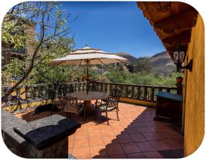 a patio with a table and chairs and an umbrella at Depa Mellado - Zona turística Guanajuato in Guanajuato
