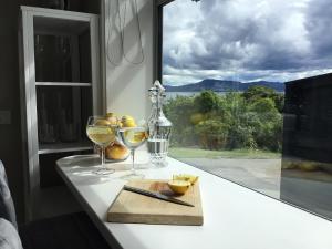 a counter with two glasses of wine and a window at Spectacular Lake Views in Rotorua