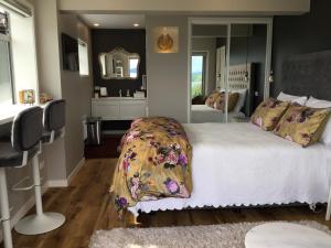 a bedroom with a large bed and a mirror at Spectacular Lake Views in Rotorua