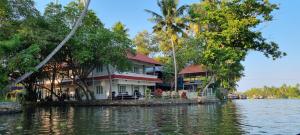 a house on a island in a body of water at Chilanka Lake View Resort in Alleppey