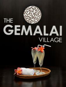 two martini glasses sitting on a table with the german challenge sign at The Gemalai Village in Pantai Cenang