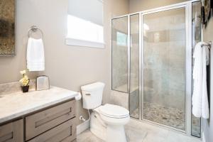 a white bathroom with a shower and a toilet at Century Oak House in Spring Branch