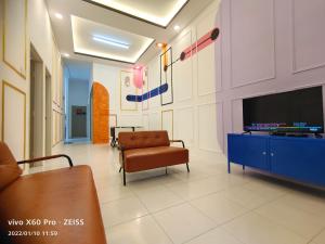 een woonkamer met een tv en een bank en een stoel bij CLASSIC ENGLISH @ CH in Tanah Rata