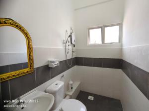 een badkamer met een toilet, een wastafel en een spiegel bij CLASSIC ENGLISH @ CH in Tanah Rata +52 foto's