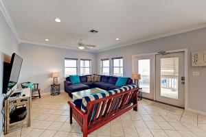 a living room with a blue couch and a tv at Gulf Breezes & Dune Dreams in Port Aransas