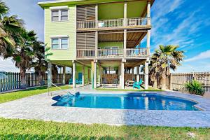 a house with a swimming pool in front of a house at Gulf Breezes & Dune Dreams in Port Aransas