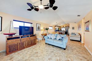 a living room with a blue couch and a flat screen tv at Sunflower Hello in Port Aransas