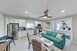 a living room with a green couch and a kitchen at Dolphins Heart & Palms Starfish in Rockport