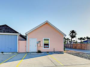 a pink building in a parking lot at Sail Away at Pirate's Bay Unit 113 in Port Aransas