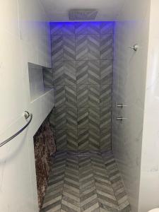 a bathroom with a walk in shower with a tile floor at Depa Rayas - Zona turística Guanajuato in Guanajuato