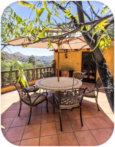 a table and chairs on a patio with a tree at Depa Rayas - Zona turística Guanajuato in Guanajuato