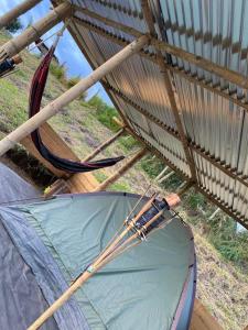 une tente installée sous un toit au-dessus d'un champ dans l'établissement CAMPING LOS ROBLES POPAYÁN, à Florencia