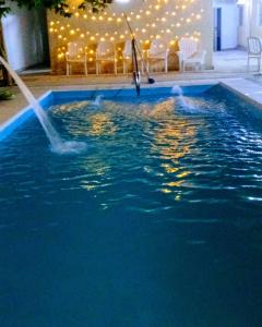 una persona está jugando en una piscina con una fuente en Nuevo Hotel Roble en Termas de Río Hondo