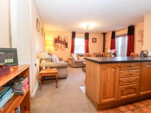 ein Wohnzimmer mit einer Küche und ein Wohnzimmer mit einem Sofa in der Unterkunft The Ramblers' Annex in North Tuddenham