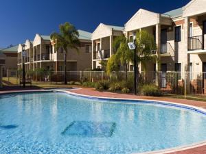 einen Pool vor einigen Apartmentkomplexen in der Unterkunft Country Comfort Perth in Perth