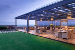 a restaurant with tables and chairs on a roof at Vivanta Bhubaneswar DN Square in Bhubaneshwar