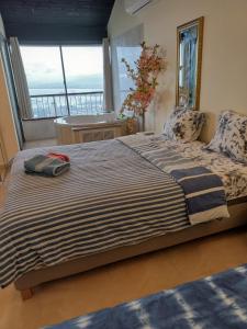 a large bed in a room with a large window at Panorama Bay View 3 room in Haifa
