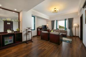 a living room with a couch and a television at The Tray Hotel Hai Phong in Hai Phong