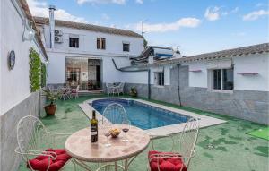 d'une terrasse avec une table et des chaises à côté de la piscine. dans l'établissement 5 Bedroom Awesome Home In Trasmulas, Granada, à Trasmulas