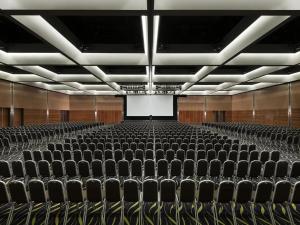 ein leeres Auditorium mit schwarzen Stühlen und einem Bildschirm in der Unterkunft Crown Promenade Perth in Perth