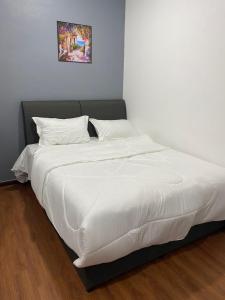 a bed with white sheets and pillows in a room at Hi TechSTAY in Lunas