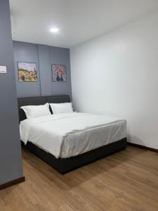 a bedroom with a large bed with white sheets at Hi TechSTAY in Lunas