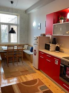 uma cozinha e sala de estar com armários vermelhos e uma mesa em Dara House em Plovdiv