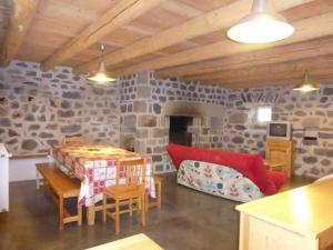 a living room with a stone wall at Gîte charmant pour 8 pers à Rauret avec cheminée, terrasse et accès "Tourisme et Handicap" - FR-1-582-186 in Rauret