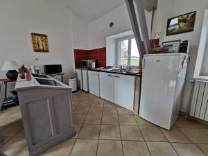 a kitchen with a white refrigerator and a counter at Gîte familial au cœur des gorges de la Loire avec équipements bébé et loisirs extérieurs - FR-1-582-238 in Lavoûte-sur-Loire +3 photos