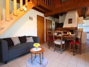 a living room with a couch and a table at Petit Gîte Enchanté au Cœur de la Forêt du Meygal, Proche du Lac Bleu - FR-1-582-272 in Champclause