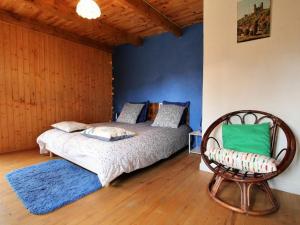 1 dormitorio con 1 cama y 1 silla en una habitación en Gîte Saint-Privat-du-Dragon, 4 pièces, 6 personnes - FR-1-582-31 en Saint-Privat-du-Dragon