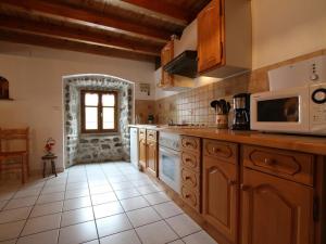 cocina con armarios de madera y microondas en Gîte Saint-Front, 4 pièces, 6 personnes - FR-1-582-267, en Saint-Front