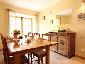 ein Esszimmer mit einem Holztisch und einer Küche in der Unterkunft Gîte Saint-Christophe-sur-Dolaison, 4 pièces, 8 personnes - FR-1-582-284 in Saint-Christophe-sur-Dolaison