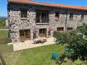 ein Steinhaus mit einer Terrasse und einem Hof in der Unterkunft Gîte à la ferme à Saint-Christophe-sur-Dolaison avec terrasse et chambres privatives - FR-1-582-284 in Saint-Christophe-sur-Dolaison + 4 Fotos