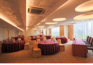 a banquet hall with tables and chairs in a room at E Hotel in Chennai