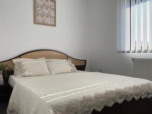 a bedroom with a bed with a white comforter at Mares Rentals Residence Magurele in Măgurele