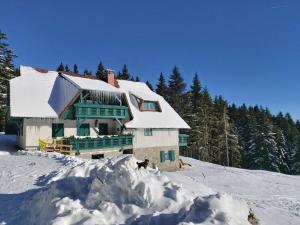a house on a snowy hill with a pile of snow at Apartma Bellevue Rogla in Vitanje
