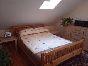 a bedroom with a wooden bed in a attic at Dom na Mazurach in Przerwanki