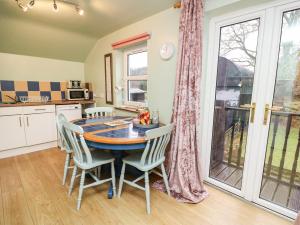 a kitchen and dining room with a table and chairs at Waun Fforest in Rhyd-cymmerau