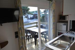 a kitchen with a balcony with a table and chairs at Camping Valencia el Saler in El Saler
