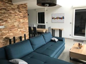 uma sala de estar com um sofá azul e uma mesa em LA CARTOUCHERIE em Toulouse