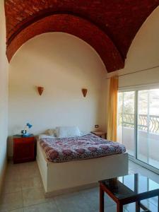 a bedroom with a bed and a large window at Amenophis Hotel in Luxor