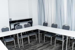 BUSINESS LIFE HOTEL BAKIRKÖY في إسطنبول: قاعة اجتماعات مع طاولة وكراسي بيضاء