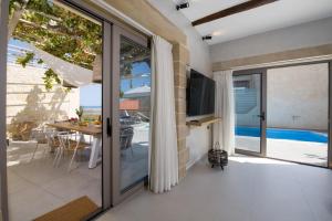 ein Wohnzimmer mit einer Glasschiebetür, die auf eine Terrasse führt in der Unterkunft Casa di Grimpili in Kolimvárion