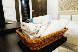 a basket filled with towels on a table next to a bed at Top Pool Villa B5 in Pattaya Central