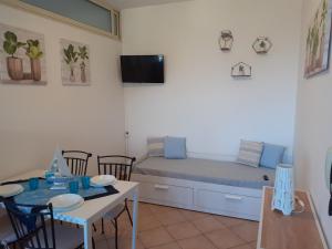 Pokój z łóżkiem, stołem i krzesłami w obiekcie Castel Tauro Apartment w Taominie