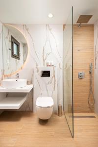 łazienka z toaletą i umywalką w obiekcie Urania Hotel w mieście Perdika