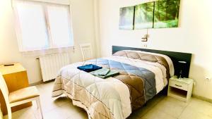 1 dormitorio con 1 cama y 1 silla en Hostal Sol Naciente, en León
