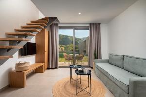 a living room with a couch and a staircase at Urania Hotel in Perdika