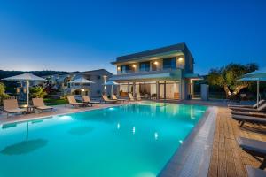 a swimming pool in front of a house at Urania Hotel in Perdika